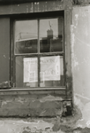 862054 Afbeelding van een bord met de tekst 'HIER WONEN MENSEN!', achter het raam van een belendende woning van het ...
